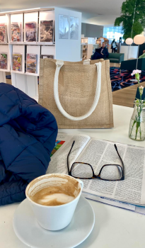 At Oodi library coffee, eyeglasses and books at a table